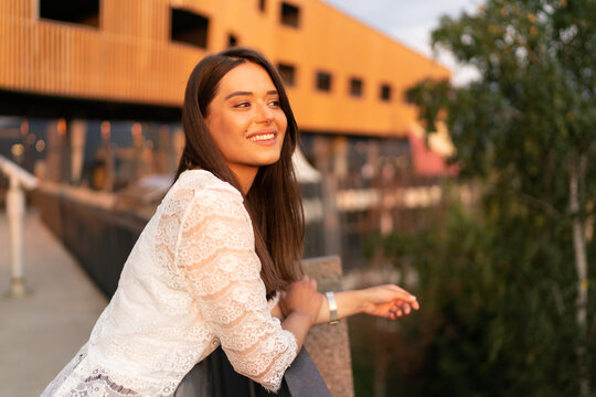 Young laughing charming woman portrait in the city at sunset