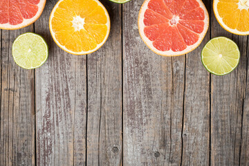 Fototapeta na wymiar Colorful fruits background with orange, grapefruit and lime halves. Top view