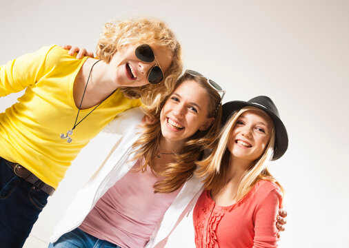 Portrait of Three, Cool Teenage Girls, Looking at Camera Smiling, Diagonal Studio Shot on White Background