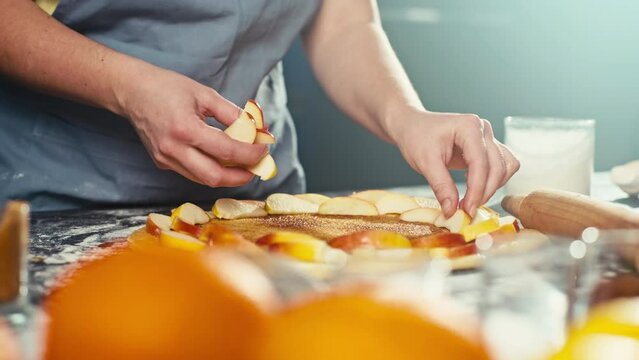 Close-up of laying apples on pie dough. Delicious sweet cakes and homemade pastries. High quality 4k footage