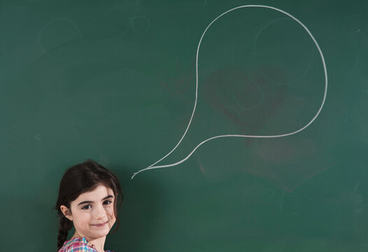 Girl in front of Chalkboard with Speech Bubble in Classroom