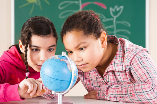 Portrait of Girls Looking at Globe in Classroom, Baden-Wurttemberg, Germany