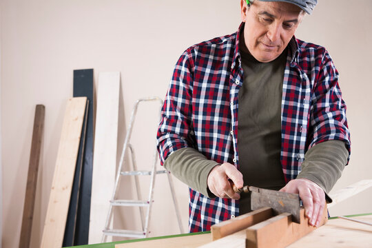 Man Cutting Lumber, Woodworking Project, in Studio