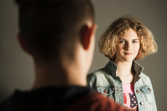 Teenage Girl looking at Teenage Boy, Studio Shot