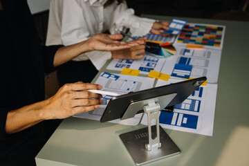 Close up ux developer and ui designer brainstorming about mobile app interface wireframe design on...