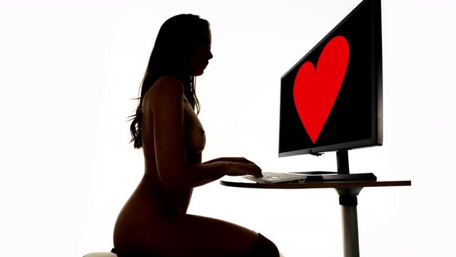 Female on a computer in silhouette 