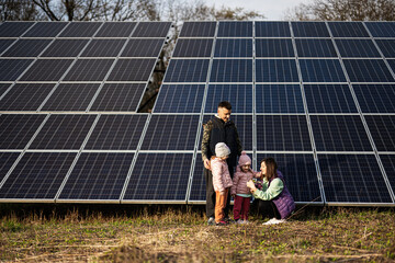 Family with two daughters on the background of solar panels.  Eco energy.