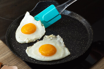 turn over of fried eggs with spatula in a frying pan