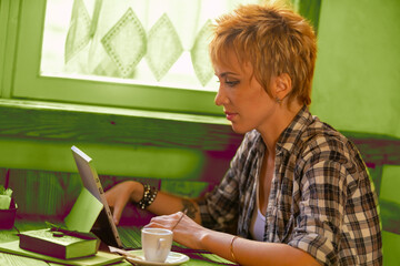 Freelance woman, short blonde hair, plaid shirt, rustic, laptop-