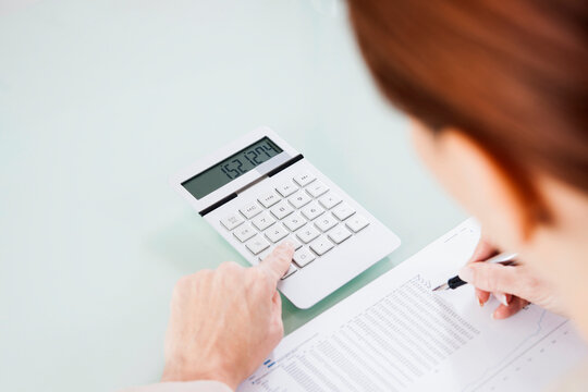 Over the Shoulder View of Mature Woman Working on Budget in Office