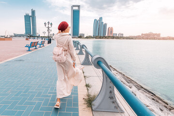 A young Indian woman proudly wears a turban as she strolls along the Abu Dhabi embankment,...