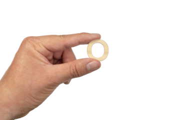 A hand holding a wooden letter o in front of a white background