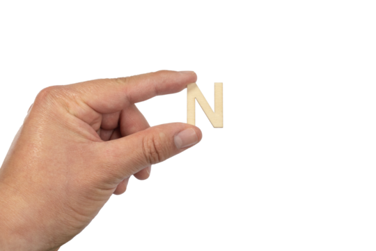 A hand holding a wooden letter n in front of a white background