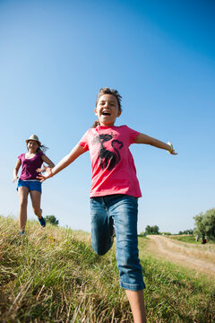 Girls running in field, Germany
