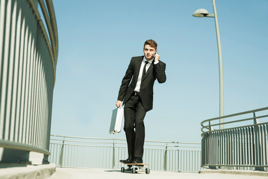 Businessman using Cell Phone while Skateboarding, Mannheim, Baden-Wurttemberg, Germany