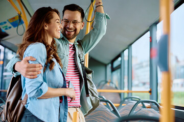 Cheerful couple having fun while riding in bus.