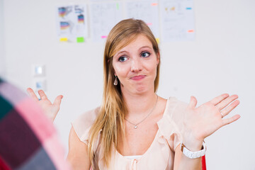 Close-up of young, blond businesswoman making hand gesture in meeting in office, Germany