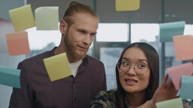 Emotional couple arguing in transparent wall close up. Stressed girl explaining