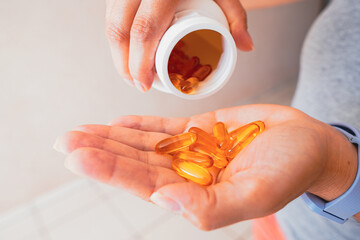 A person holds several medicine pills in his hand