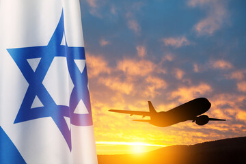 Israel flag and airplane taking off at the sunset sky. Silhouette of an airplane in the sky next to...