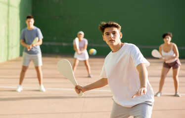 Concentrated young man paleta fronton player hitting ball with a racket © JackF