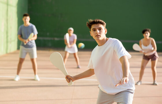 Concentrated young man paleta fronton player hitting ball with a racket