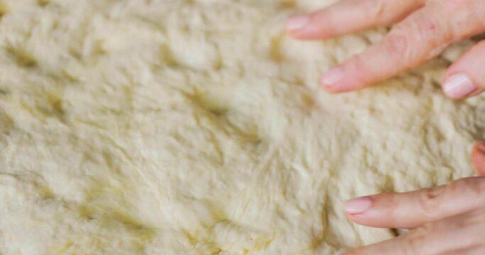 making bread with pepper and tomato paste, the dough is rolled out and pepper sauce is spread on it, sesame is added