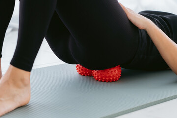 Woman lying on small balls to eliminate back pain, massage stiff muscles and lower back pain,...