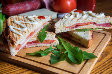 Sandwich with ham, cheese, tomatoes, lettuce, and toasted bread...homemade sandwiches on wooden background...