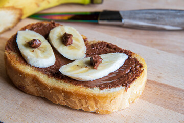 Fried bread with homemade hazelnut cream and banana on white background...sweet pastry...homemade open sandwich...