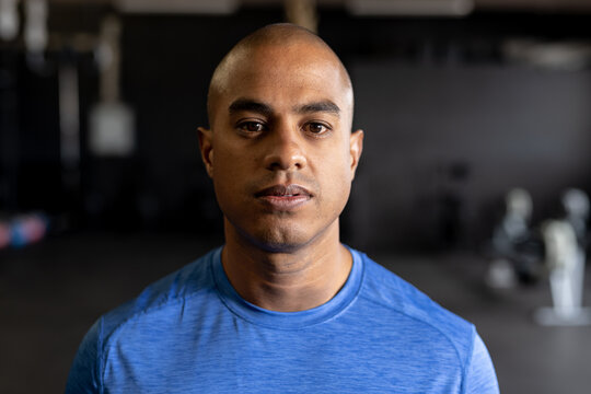 Closeup portrait of confident biracial young man with shaved head in gym