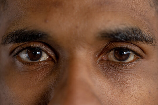 Closeup portrait of biracial young man staring with brown eyes in gym