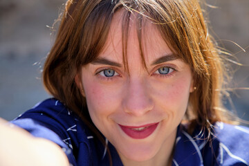 selfie from very close of a very pretty girl with blue eyes looking at camera