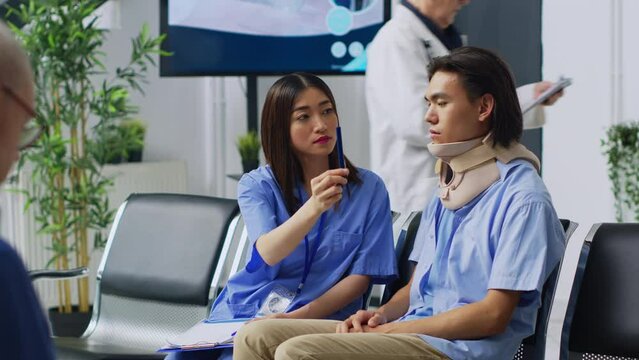 Asian nurse doing brain damage exam, checking concussion and having medical appointment with patient. Person with neck fracture wearing cervical collar in hospital waiting room. Medicine concept