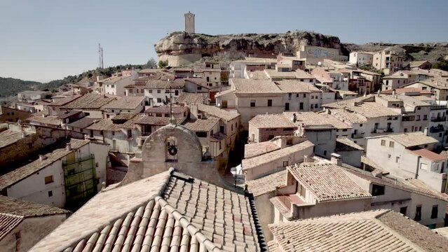 Close fly by over the old Bell tower and cemetery of the Village of Monroyo in Matarranya Region, Teruel Province, Spain