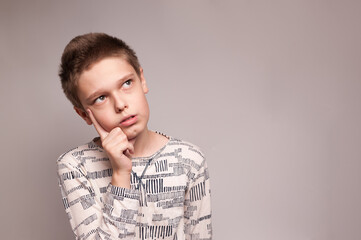 Theportrait of a boy with a thinking expression