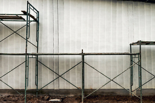 Steel frame of scaffolding construction equipment and flap backdrop painted white.