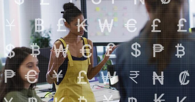 Animation of currency symbols against african american woman talking to diverse colleagues at office