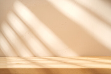 Wooden table mockup on beige stucco background with branch shadows on the wall. Mock up for branding products, presentation and health care.	