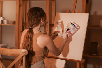 Female artist with color palettes drawing in workshop