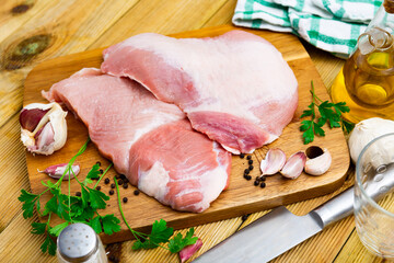Raw slice of Iberian pork secret and parsley on kitchen board