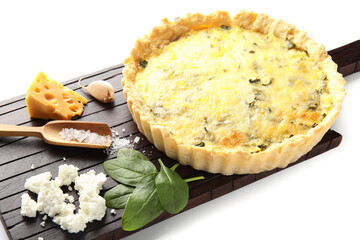 Board with delicious quiche, cheese and spinach leaves isolated on white background