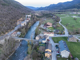 Ara river passing through the Aragonese Pyrenees village of Fiscal, in the foreground the bridge that gives access to the village from the road, mountais in the background