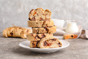 Plate with stack of tasty biscotti cookies on grunge background