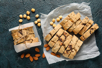 Parchment with delicious biscotti cookies and nuts on grey background