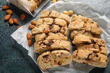 Parchment with delicious biscotti cookies and almond nuts on grey background
