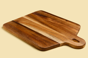 Wooden cutting board on yellow background, closeup