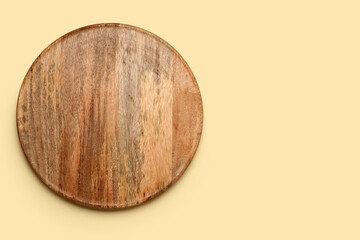 Round wooden board on yellow background