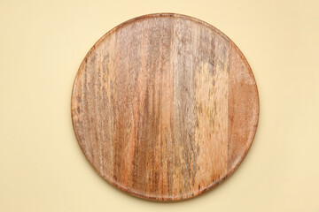 Round wooden board on yellow background