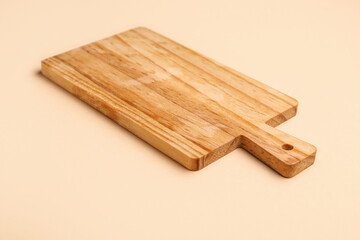 Wooden kitchen board on color background